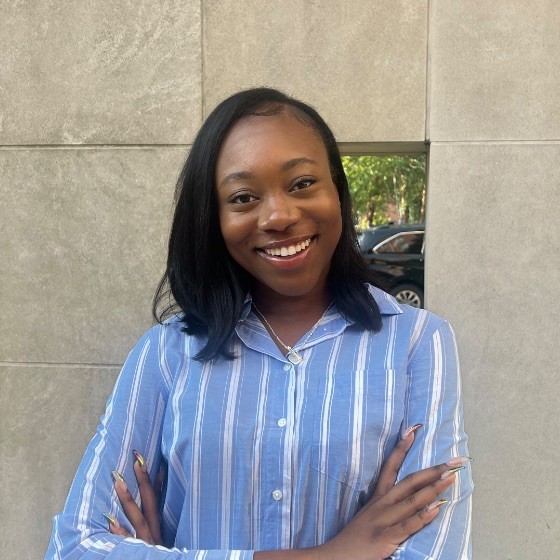 A photo of Zauryn smiling with arms crossed.